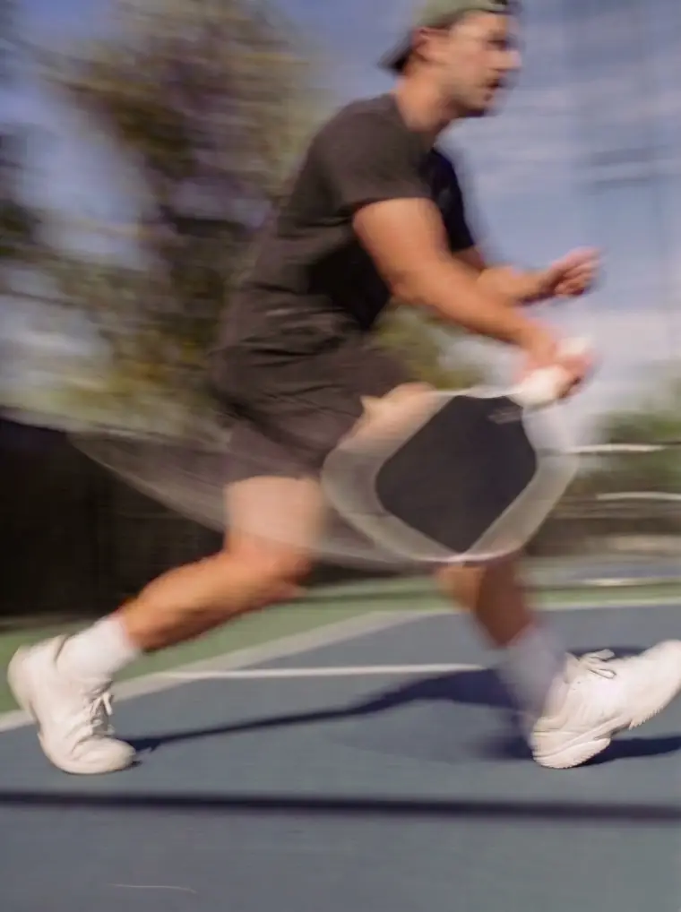 A person running with a pickleball paddle